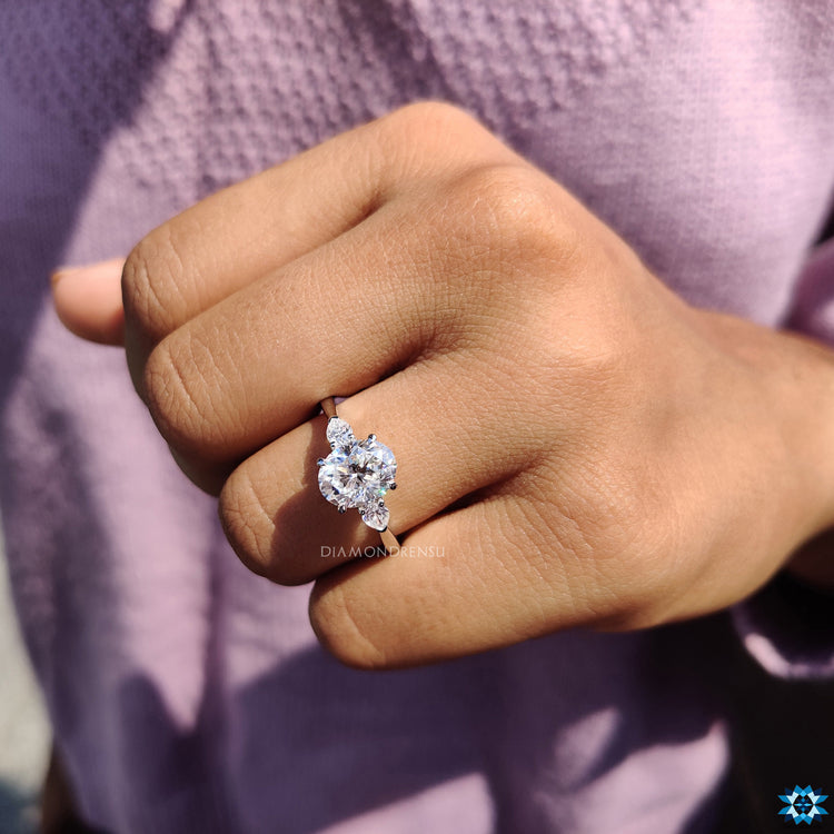 2 pear cut side stones frame central oval moissanite beautifully.
