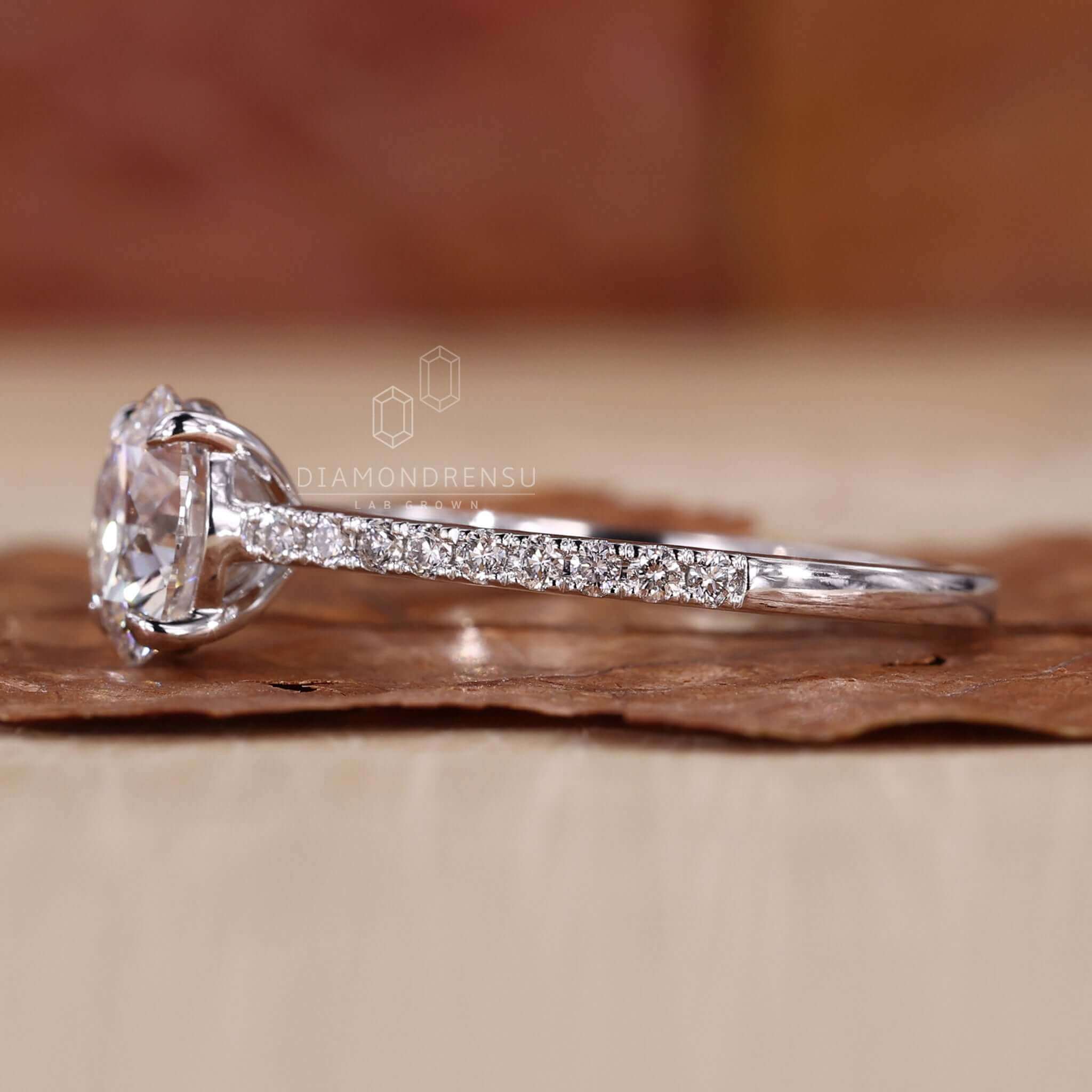 Round ring diamond crafted with a 4 prong claw setting and pave details, ideal for a UK engagement ring.