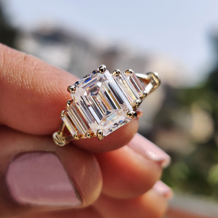 Emerald cut moissanite engagement ring in yellow gold.
