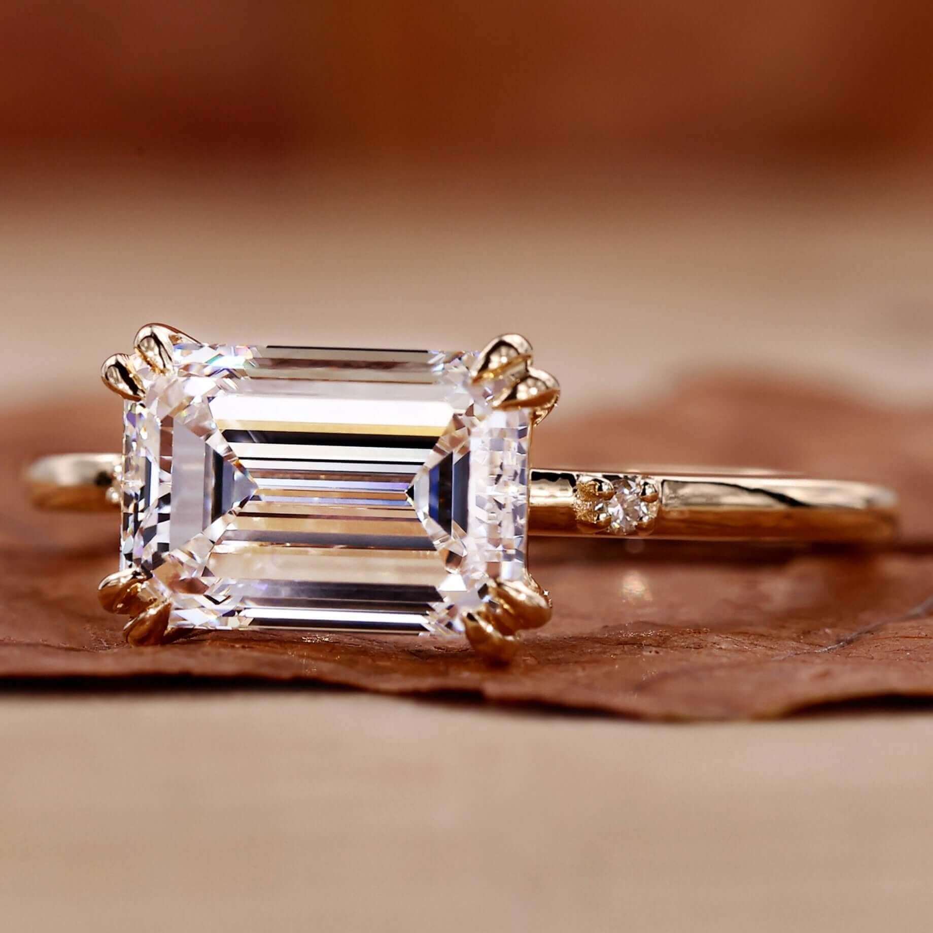 Emerald cut engagement ring with side stones in a classic design.