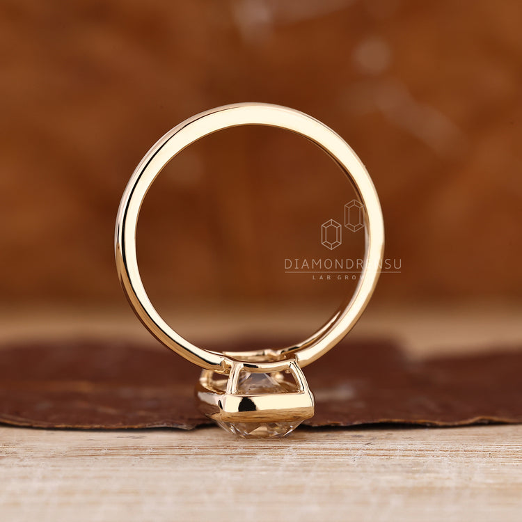 Bezel engagement ring with split shank band and solitaire style.