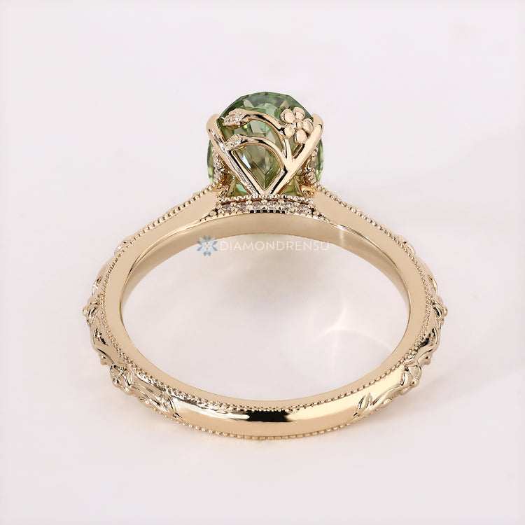Oval solitaire ring with round diamond bridge accent.