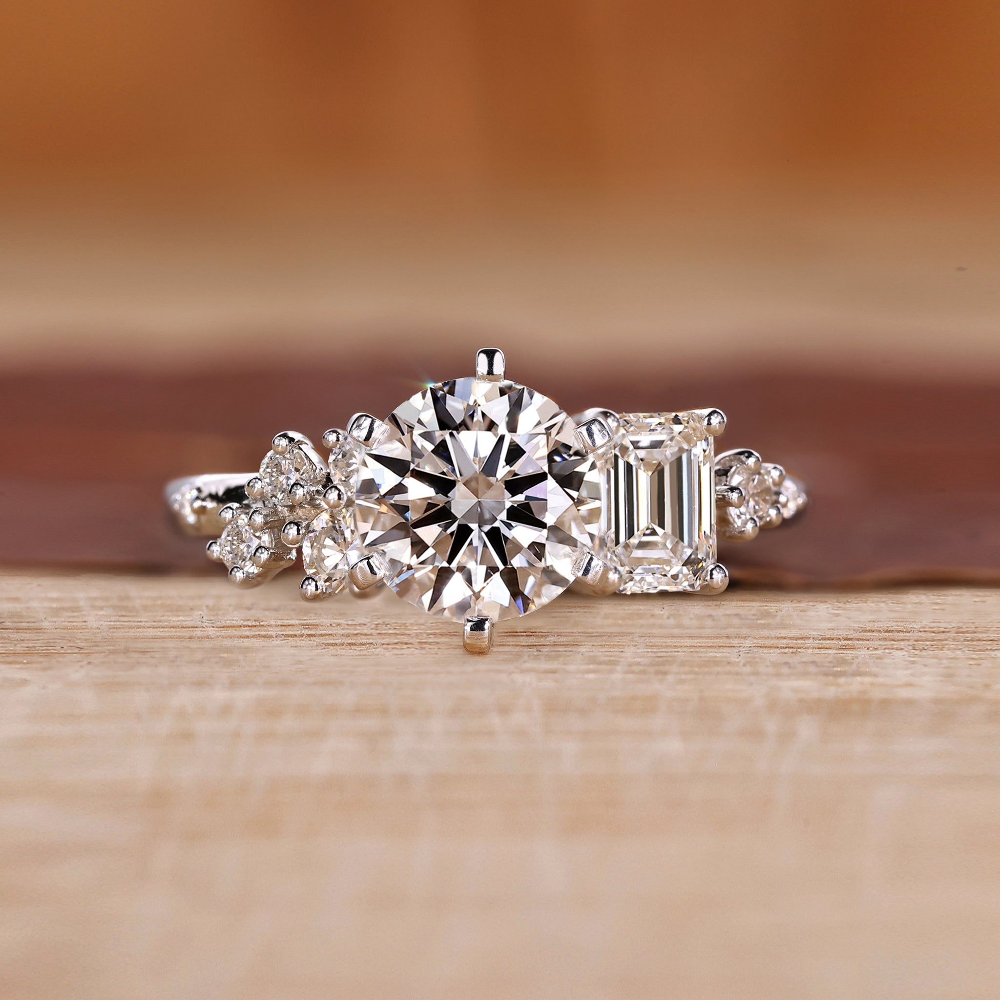 White gold engagement ring with round and emerald diamonds.
