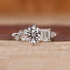 White gold engagement ring with round and emerald diamonds.
