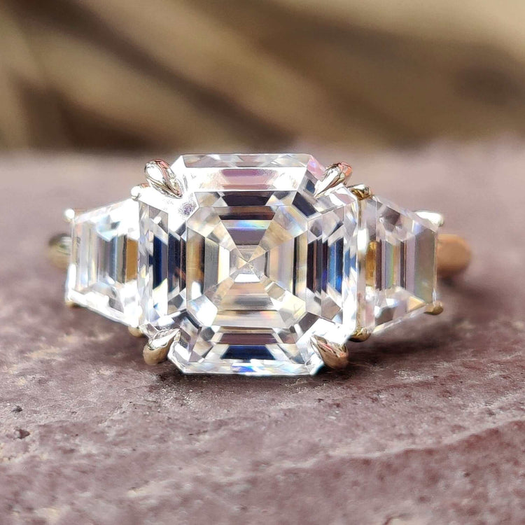 Asscher cut moissanite engagement ring with trapezoid side stones.
