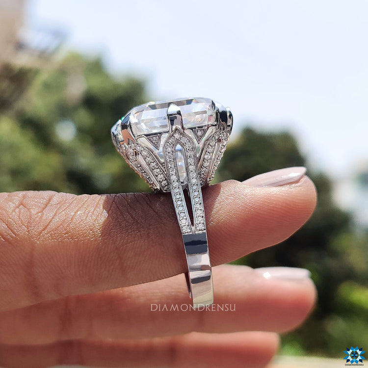 Round cut side stone complements Asscher moissanite in split shank design.
