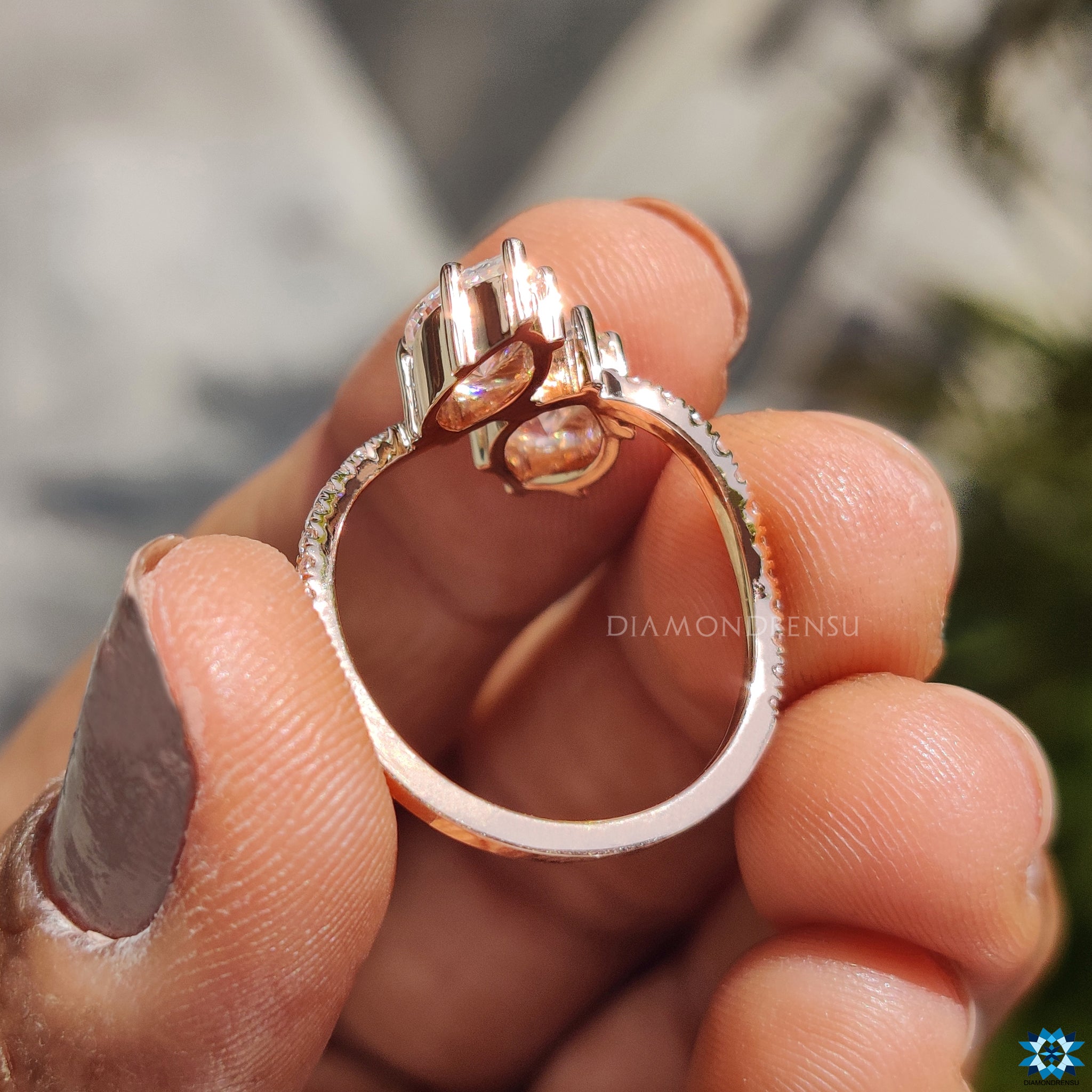 Rose gold moissanite ring with wave pave setting and secure prongs.
