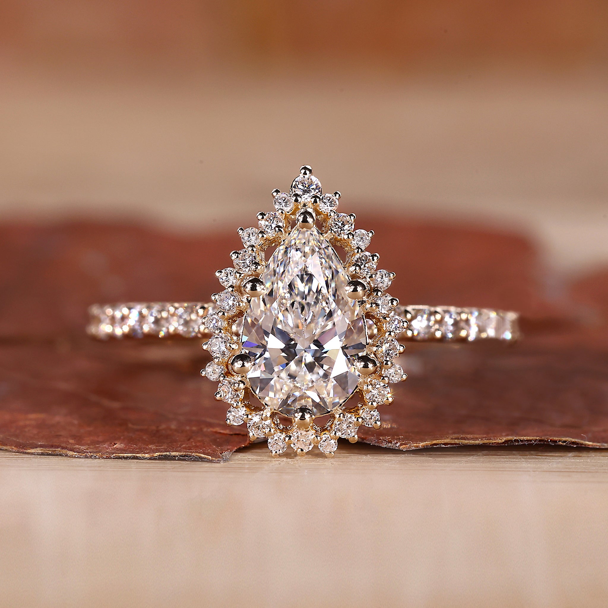 Pear cut diamond engagement ring set in yellow gold with fine detail.

