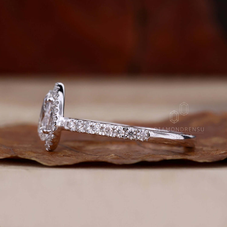 Pear shaped ring in a halo engagement rings style, featuring a 4 prong round diamond engagement ring setting.
