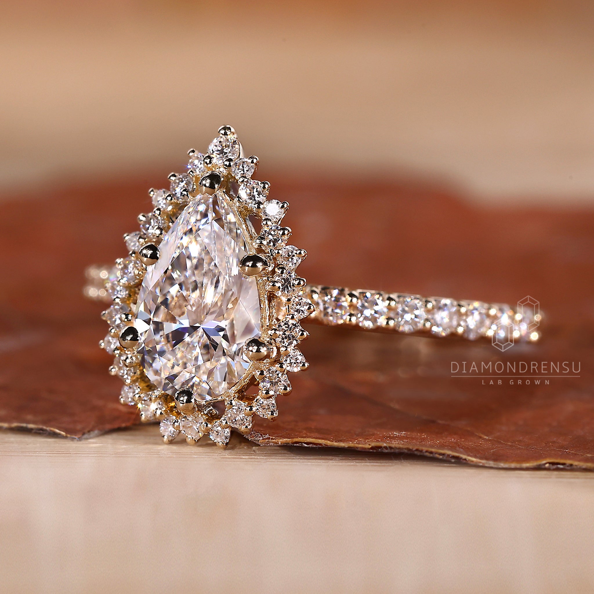 6 prong ring setting featuring a pear cut diamond and yellow gold band.
