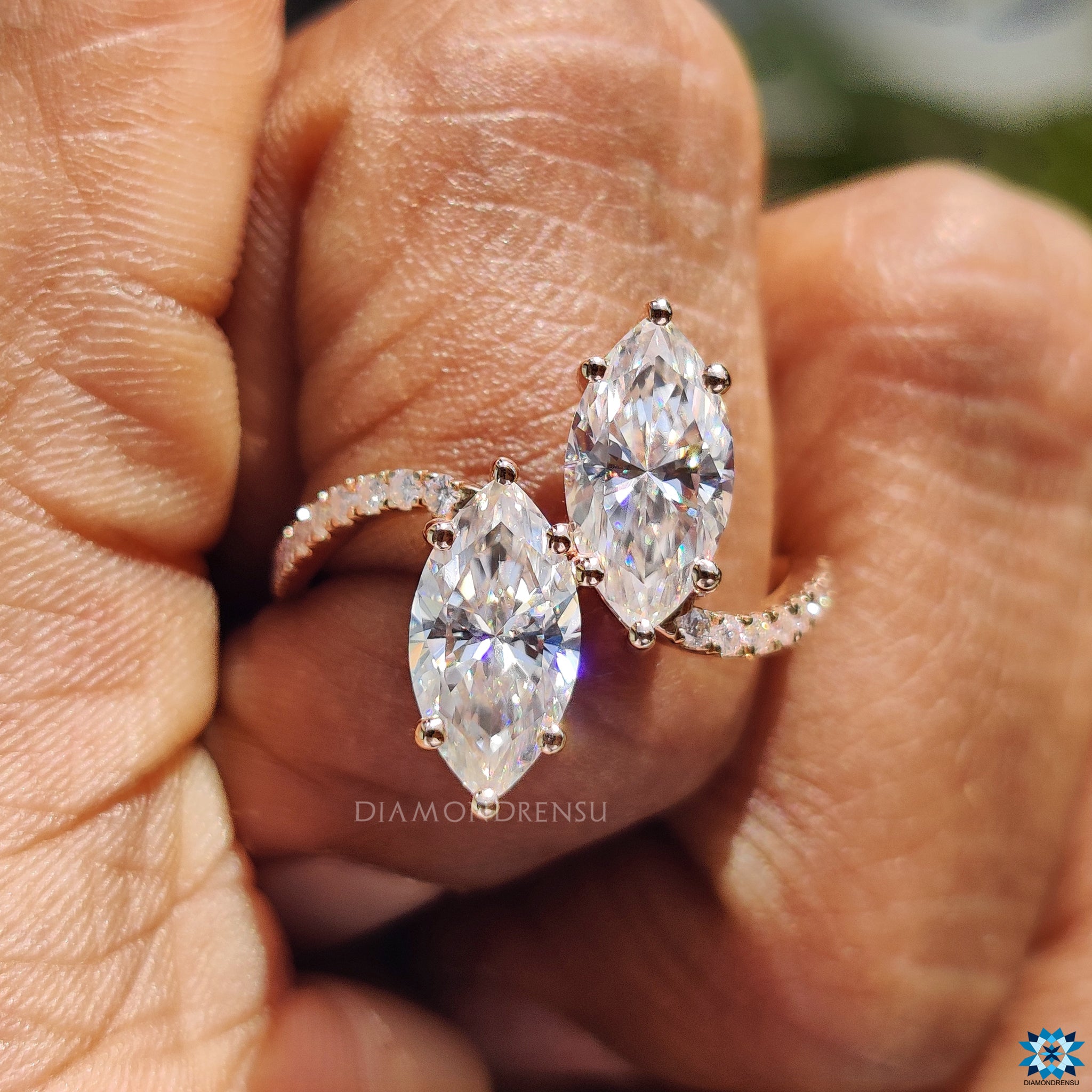 Moissanite engagement ring with marquise stones and custom pave band.
