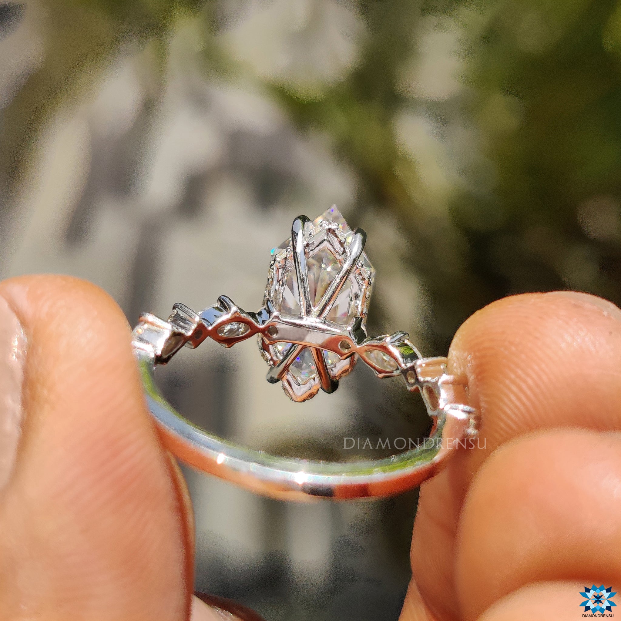 4 claw prong setting securing centre stone in hidden halo design.
