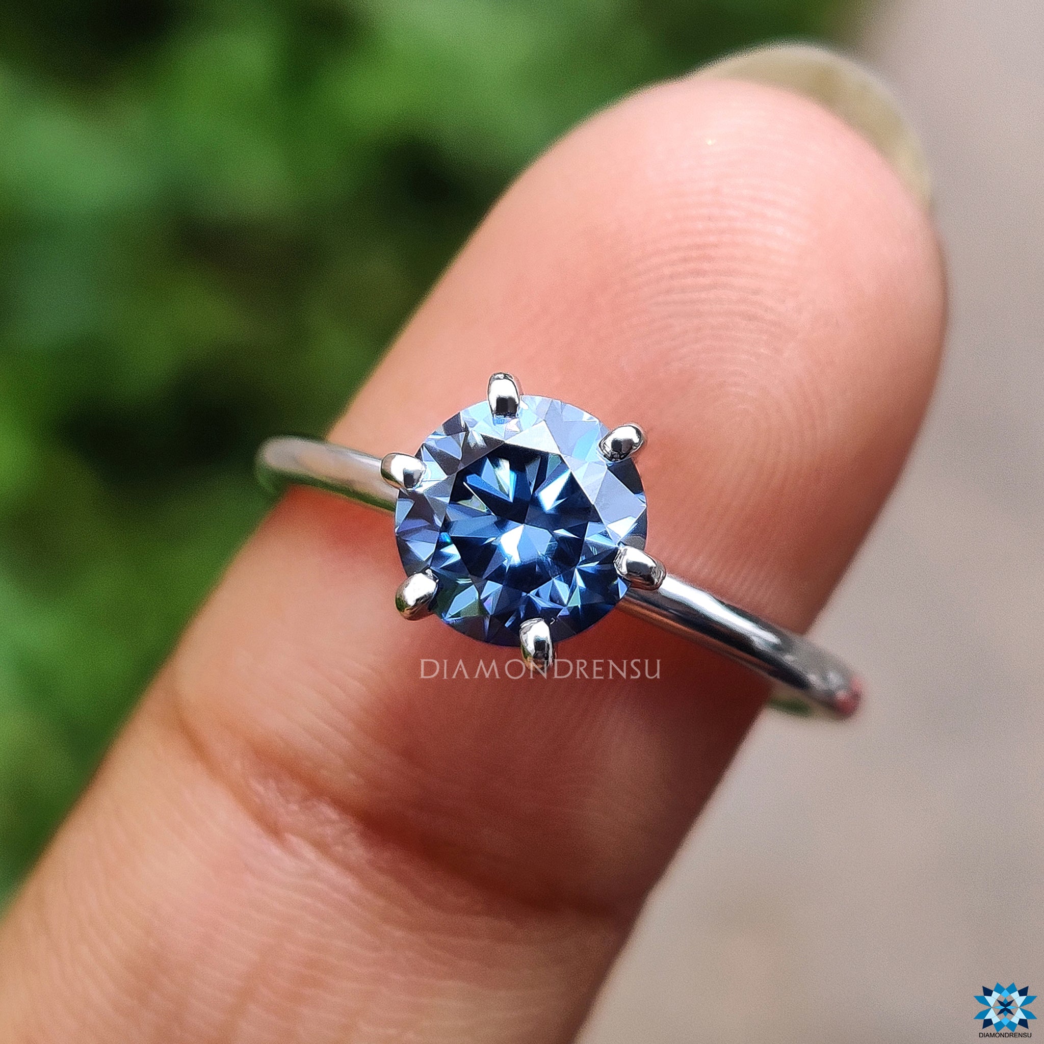 Handmade ring featuring a round blue moissanite in a 6 prong setting.
