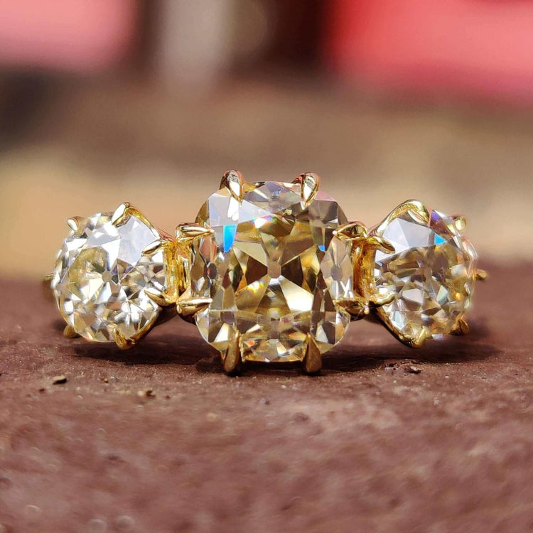 Three stone engagement ring with cushion old mine cut center.
