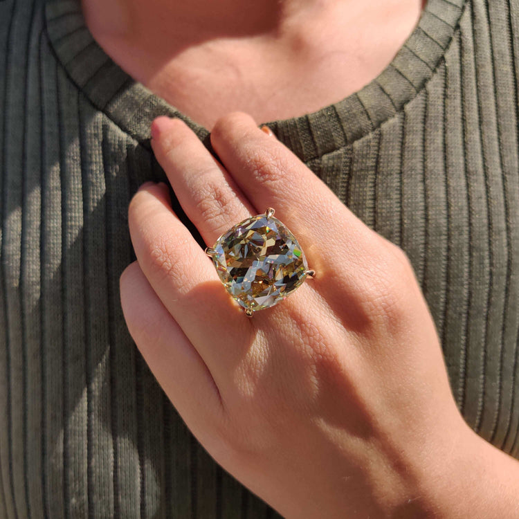 Yellow gold solitaire engagement ring with cushion cut.
