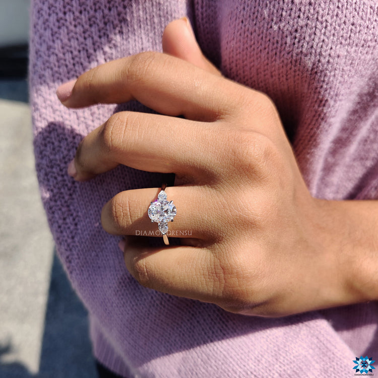 Three stone engagement ring with white gold and pear side stones.
