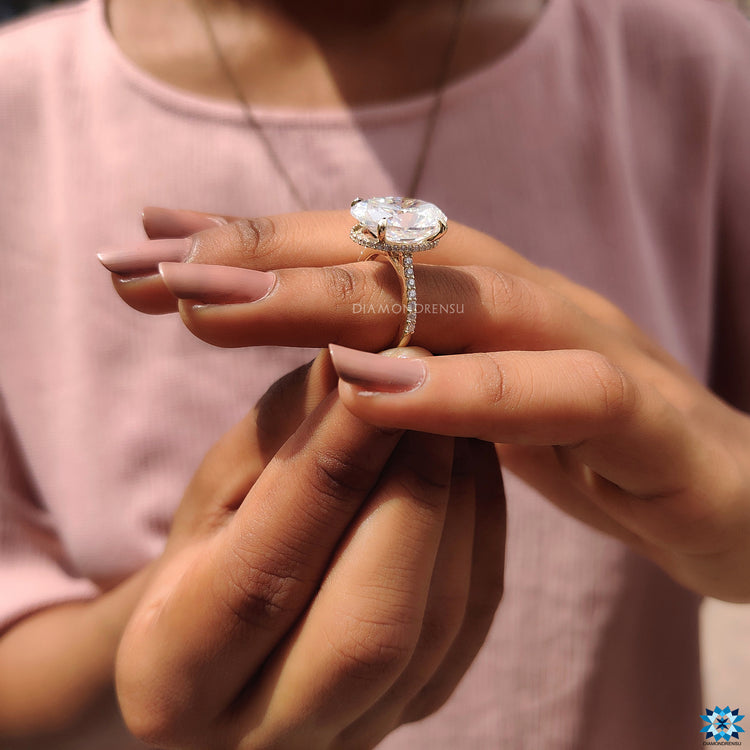 Oval cut moissanite ring in yellow gold with 4 claw setting and hidden round halo.
