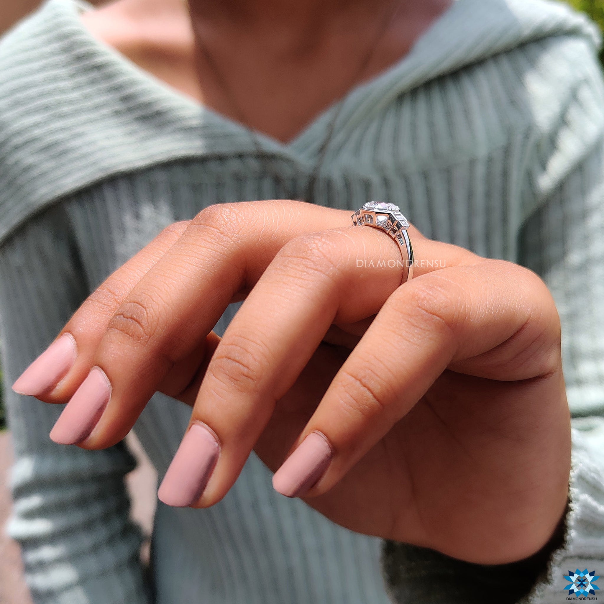 White gold engagement ring with round centre and four side moissanites.
