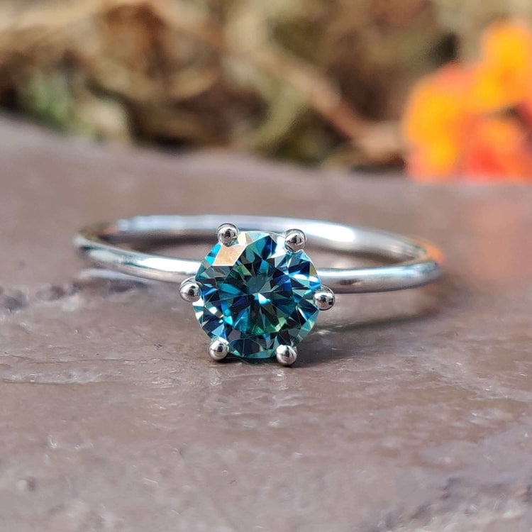Cyan blue moissanite solitaire ring in white gold.
