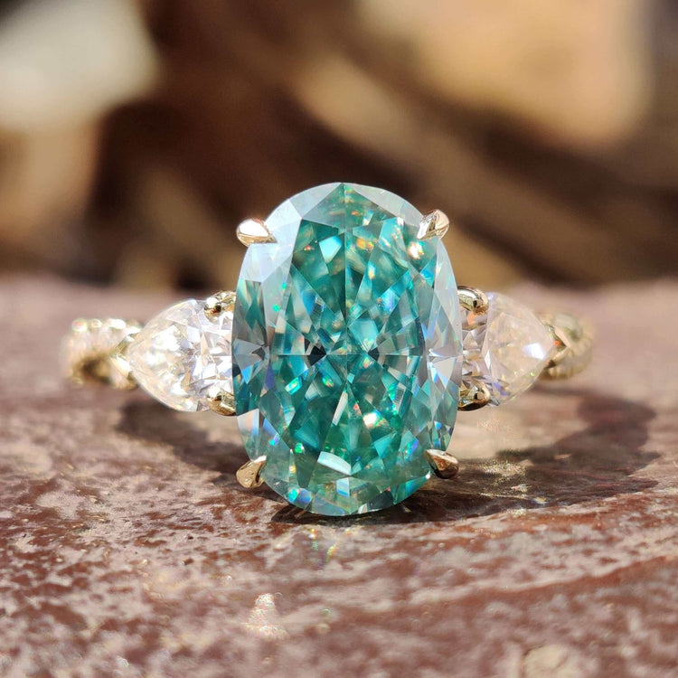 A twisted band engagement ring with a cyan blue moissanite center stone by Diamondrensu UK.
