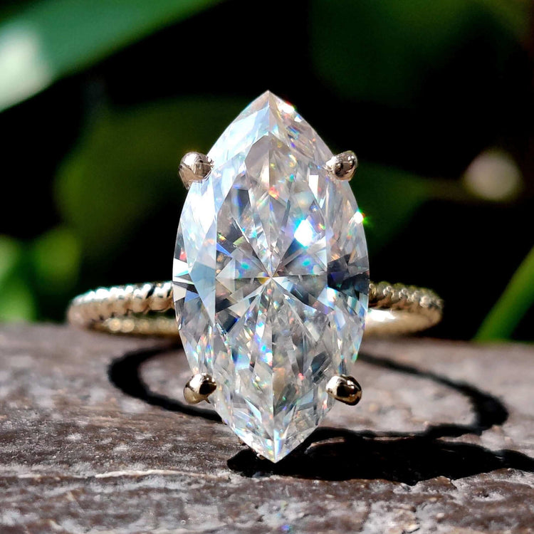 Marquise moissanite ring with round cut hidden halo setting.
