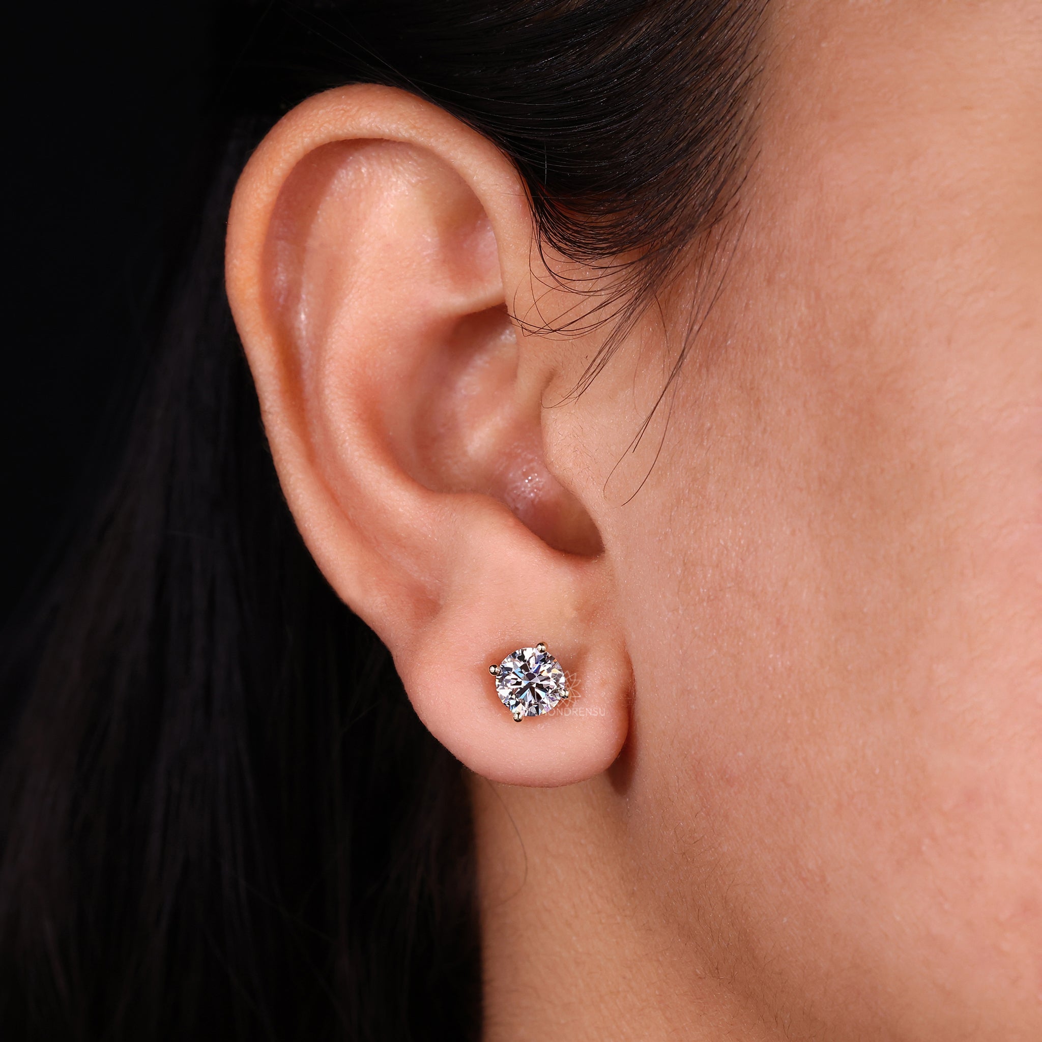 Round diamond earrings crafted as classic gold studs.