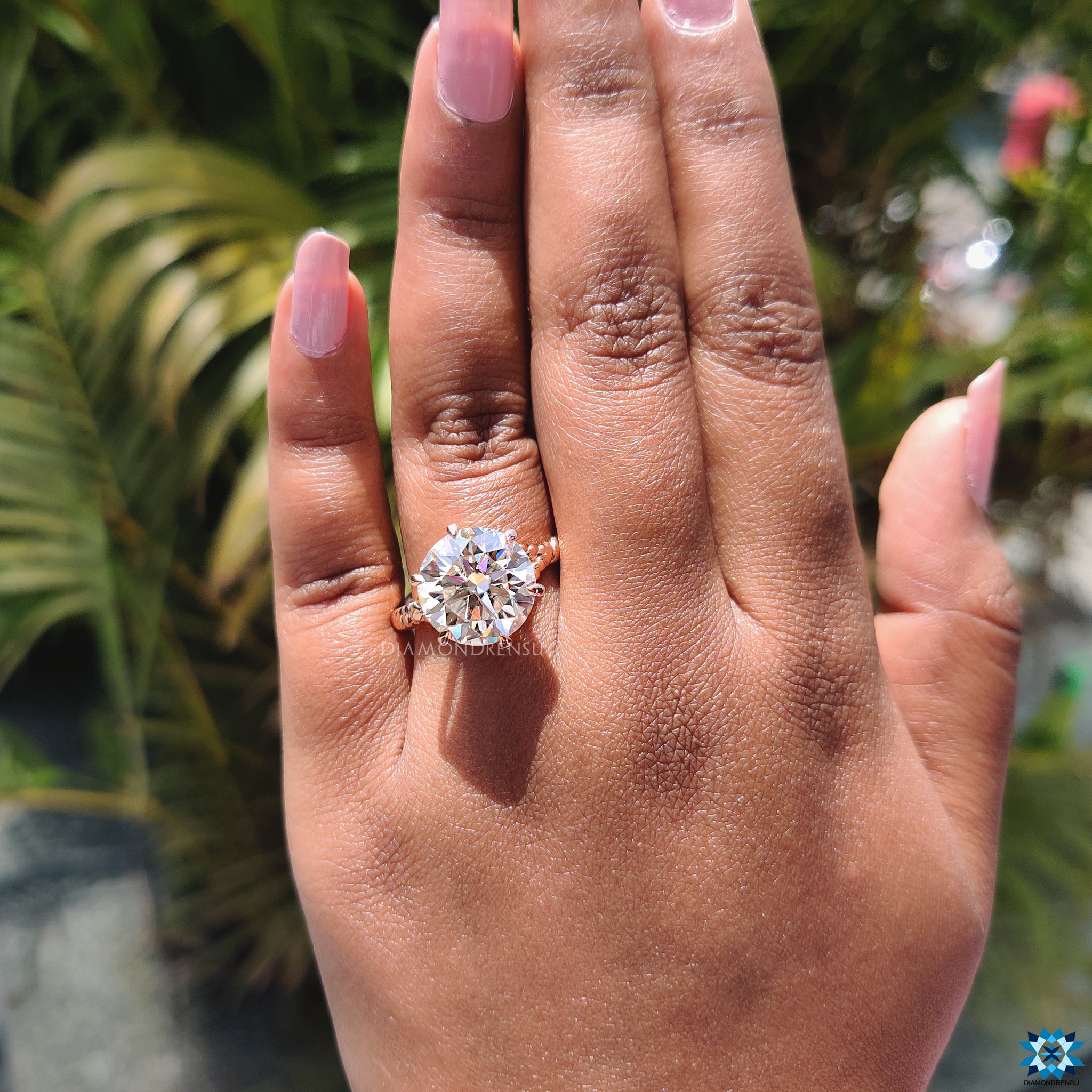 Six claw prong setting secures round moissanite in handmade rose gold.
