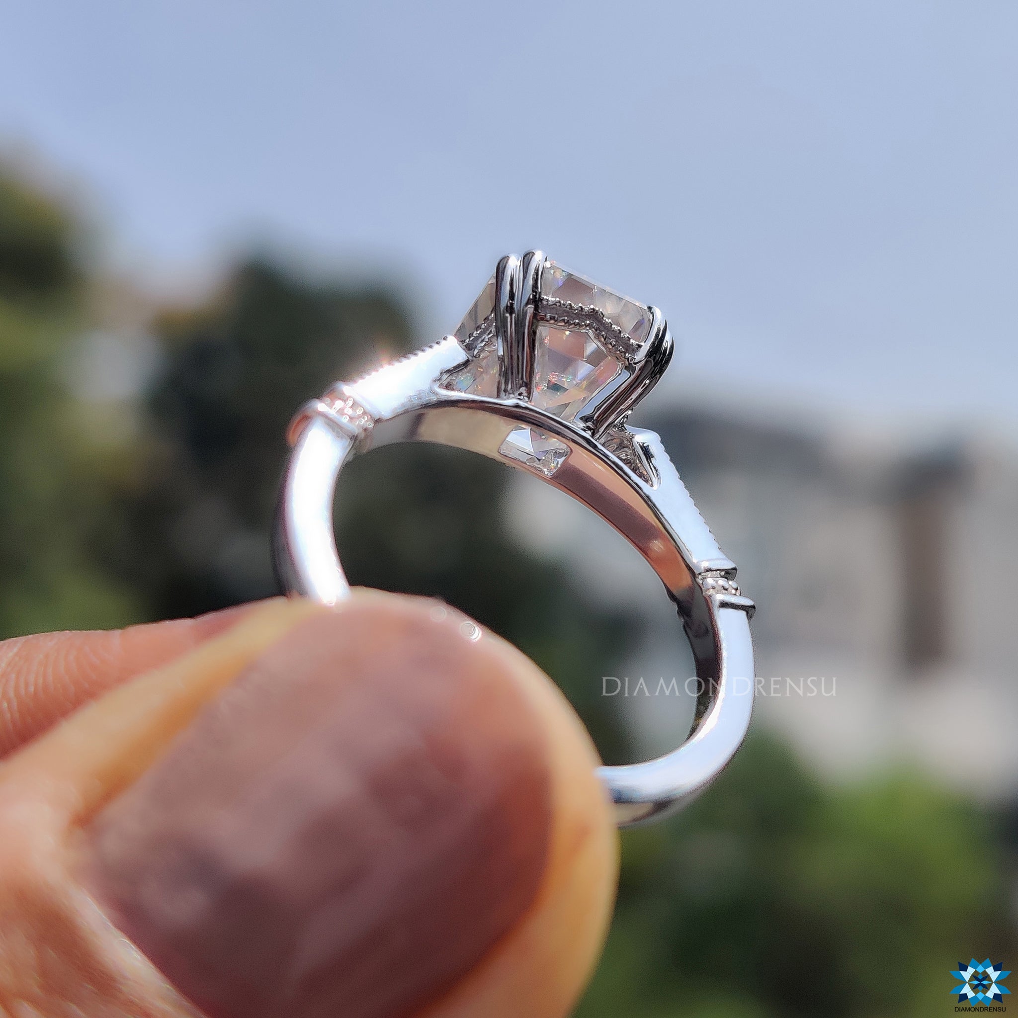 Round side stone ring in white gold with emerald cut centre.
