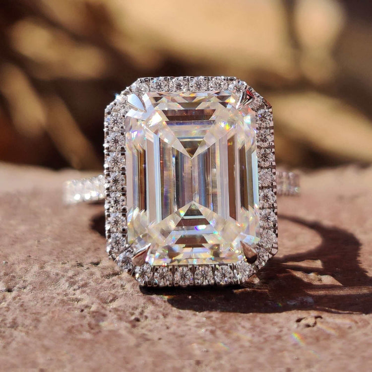 Emerald cut moissanite engagement ring with halo setting.
