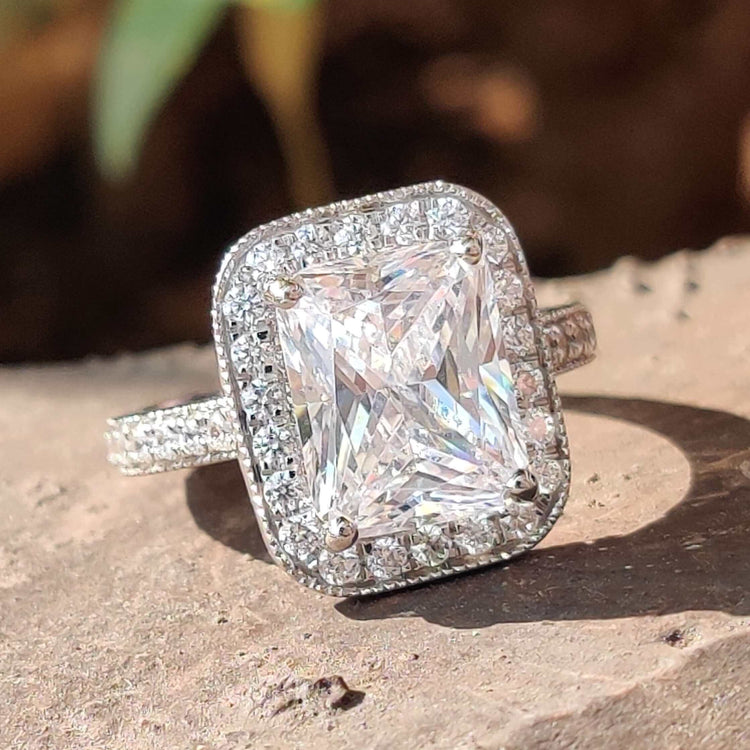 Radiant cut moissanite ring with halo setting.
