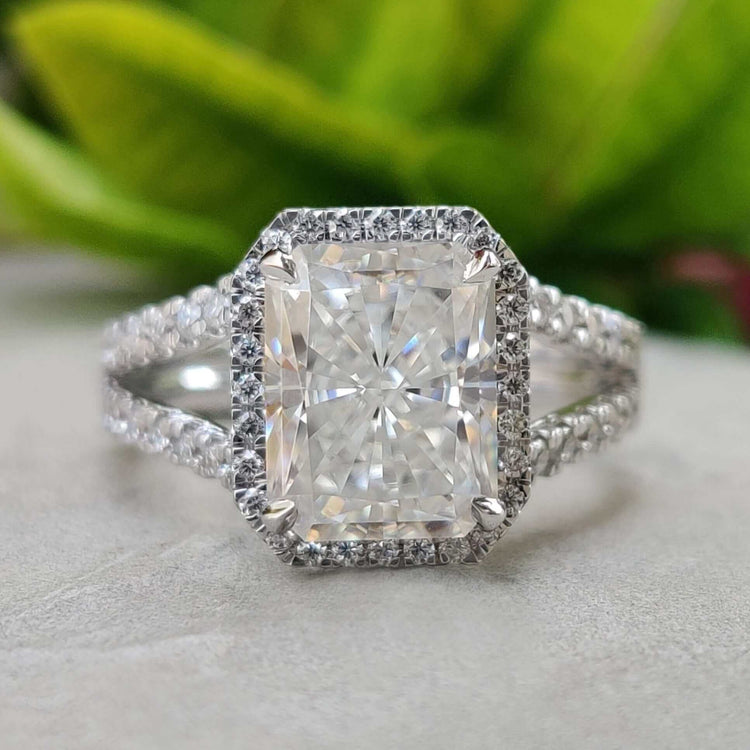 Radiant cut moissanite ring with halo and split shank.
