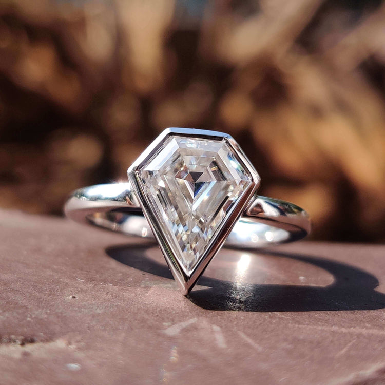 Shield cut engagement ring with bezel setting.
