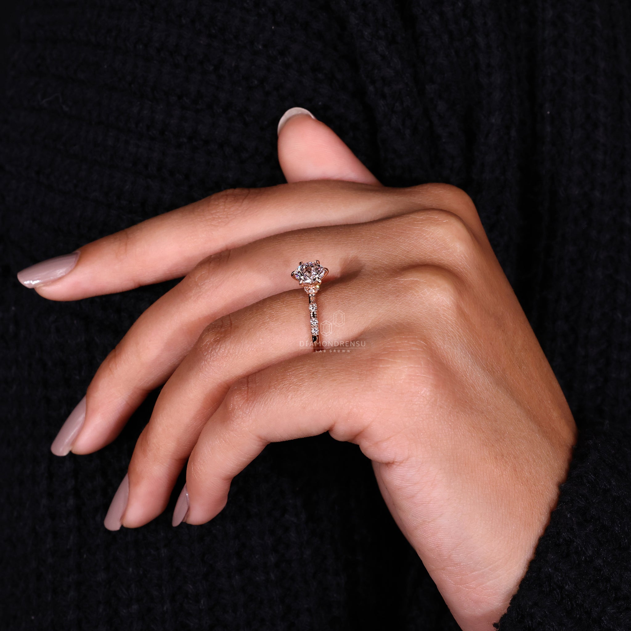 Rose gold ring with round cut side stones and a 6 prong setting.
