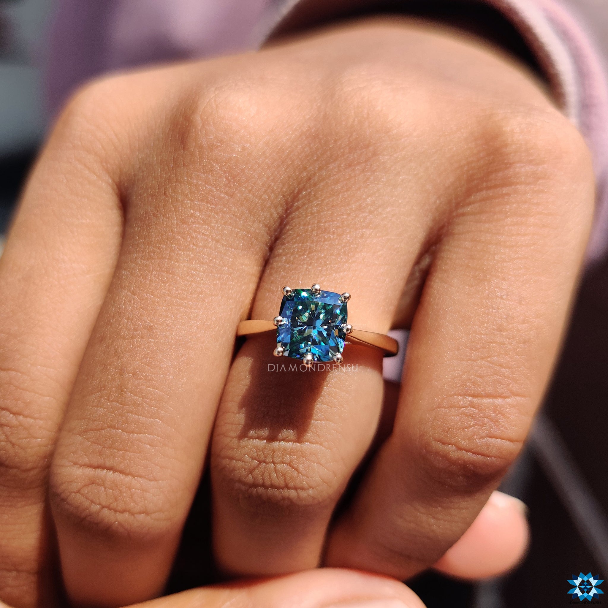 Cyan blue moissanite in cushion cut with round hidden halo setting.
