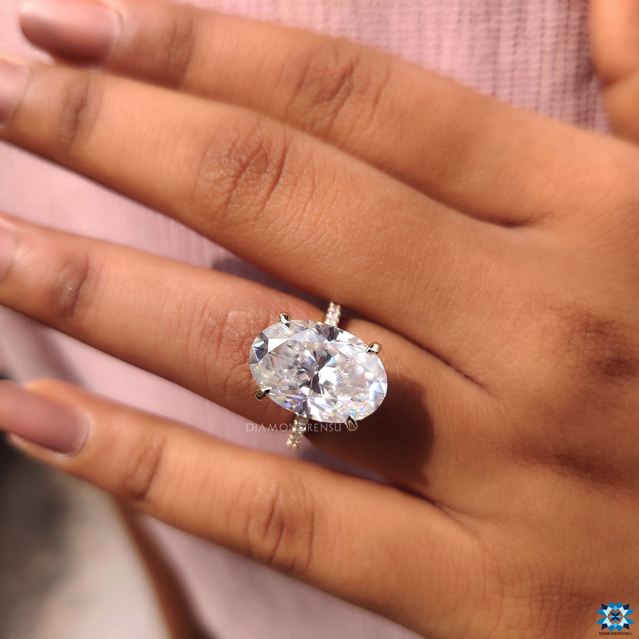 Yellow gold engagement ring with 4 claw prong and oval cut moissanite center stone.
