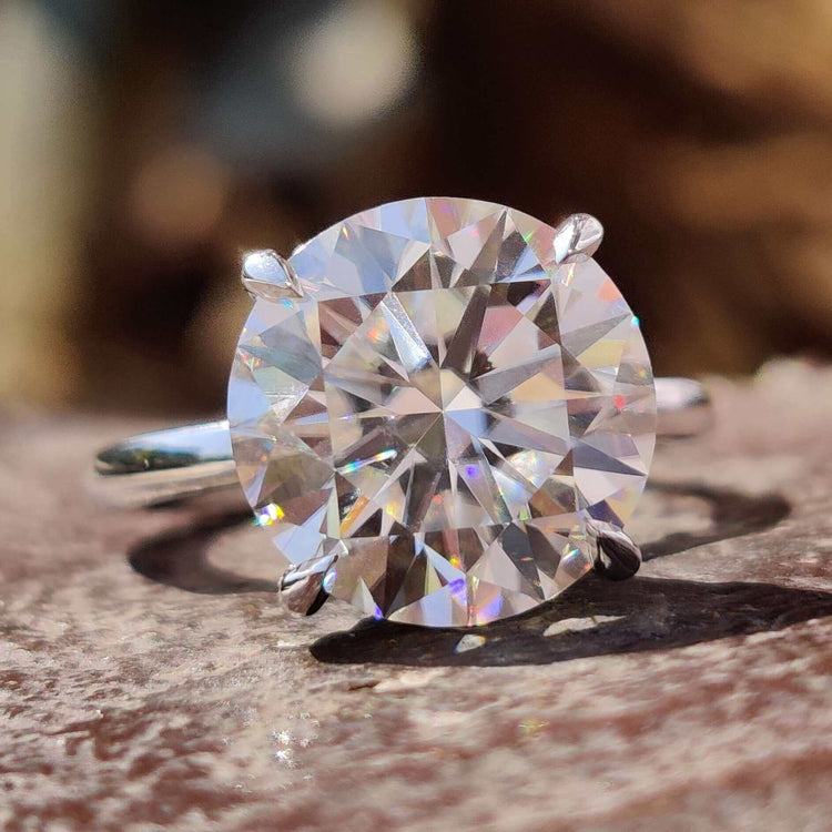 Round cut hidden halo engagement ring with moissanite solitaire.
