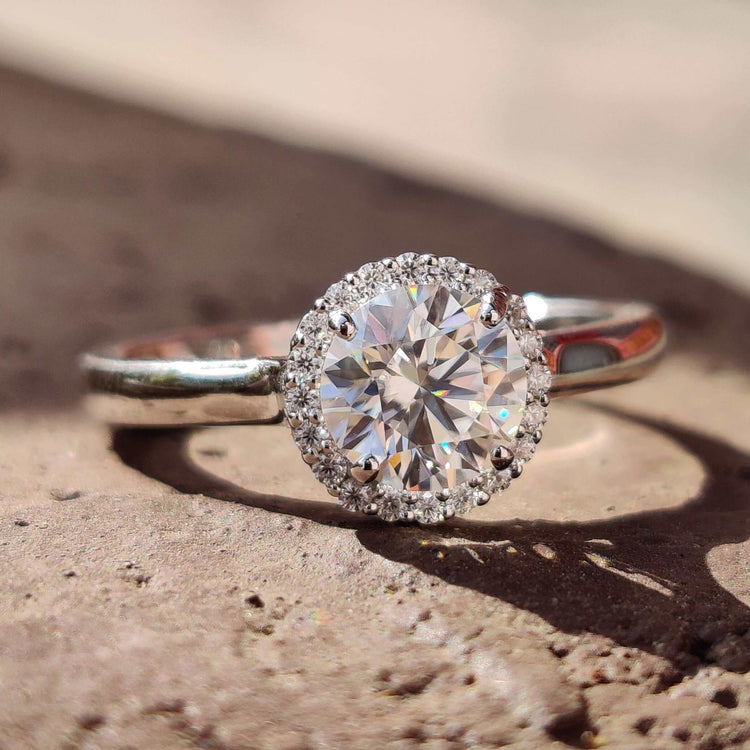 Moissanite halo ring with round cut center stone.
