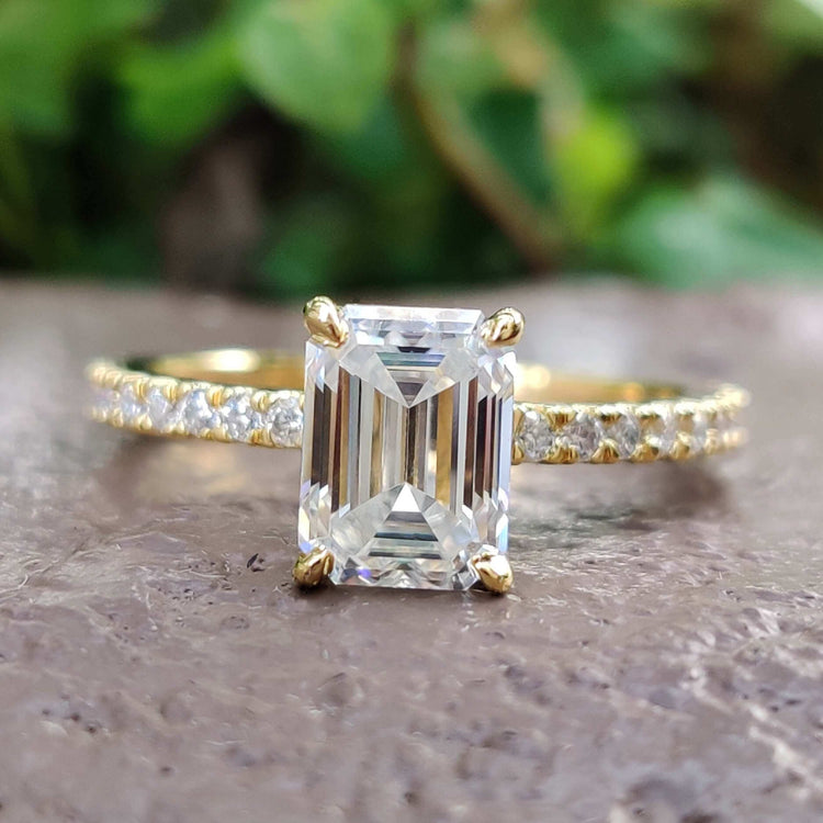 Emerald cut moissanite engagement ring in yellow gold.
