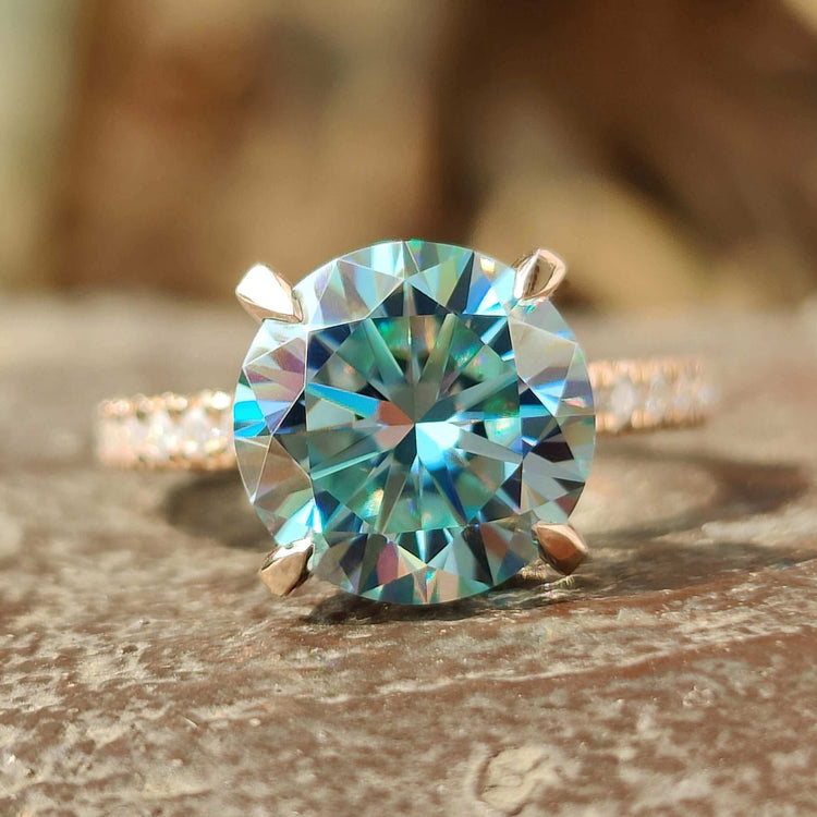 Rose gold hidden halo pave engagement ring with round cut moissanite.
