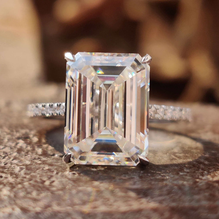 Emerald cut moissanite engagement ring with hidden halo setting.
