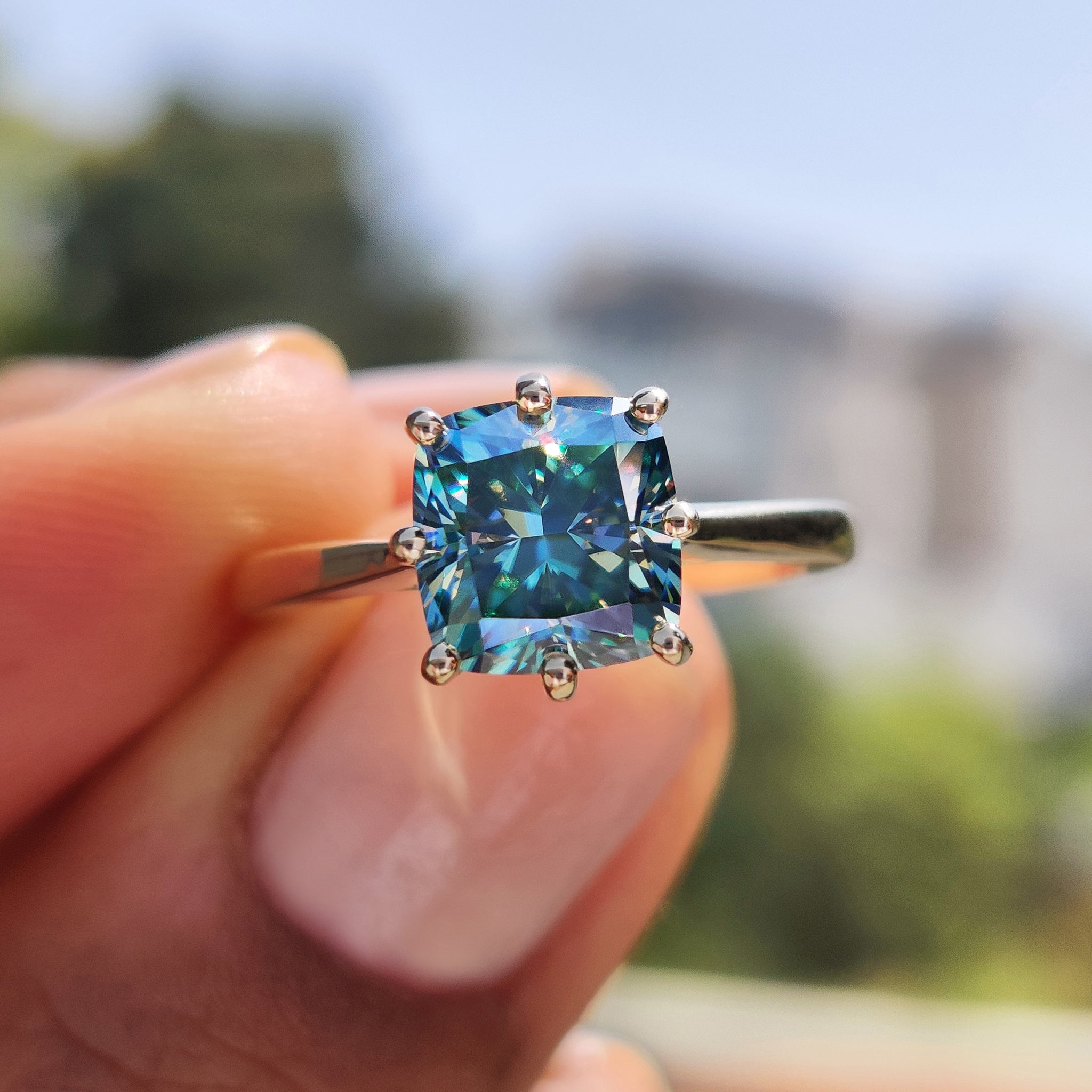 Cushion cut moissanite engagement ring with yellow gold tapered shank band.
