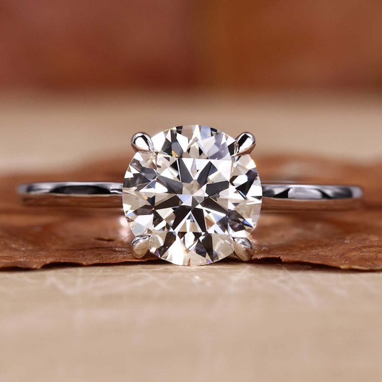 Solitaire engagement ring with a classic round diamond and a 4 prong claw setting, perfect for timeless proposals.