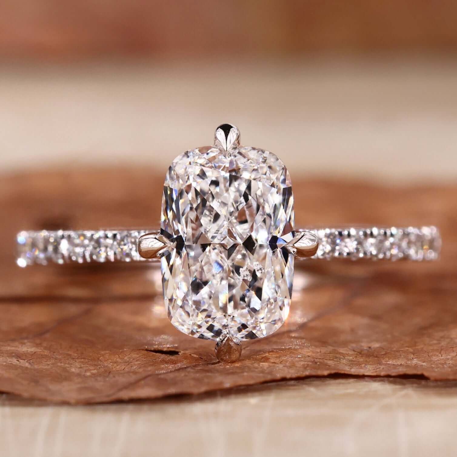 Elongated cushion engagement ring with a sparkling diamond in a handmade design.