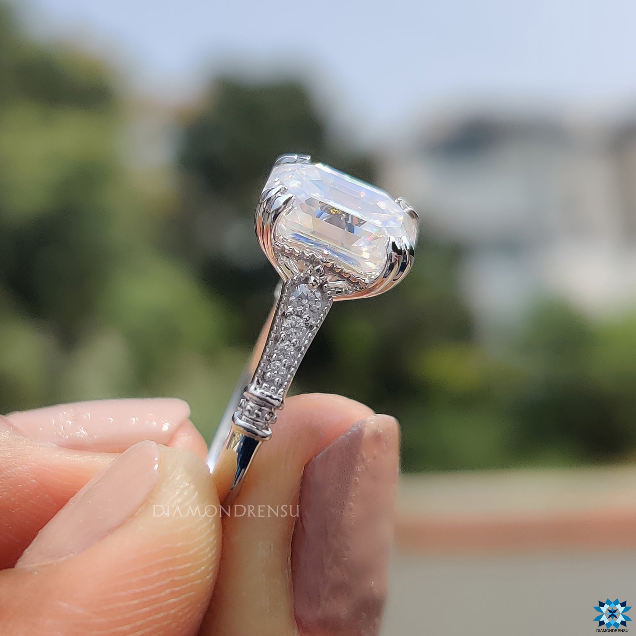 Moissanite ring UK with emerald cut, round sides, and vintage style.
