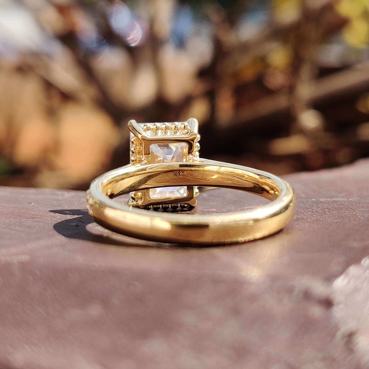 Elegant engagement ring with emerald moissanite and custom pave detailing.
