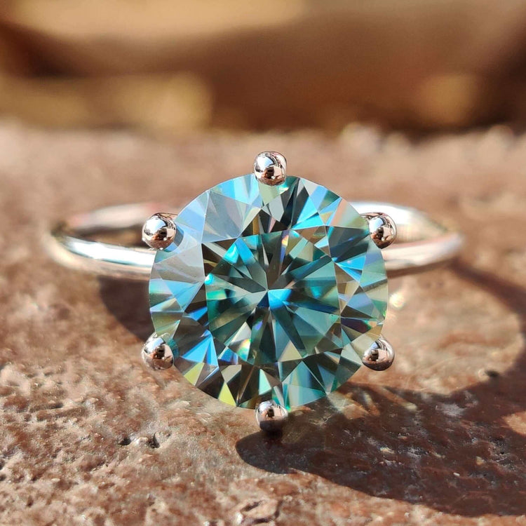 Round moissanite engagement ring in white gold with a clean solitaire setting.
