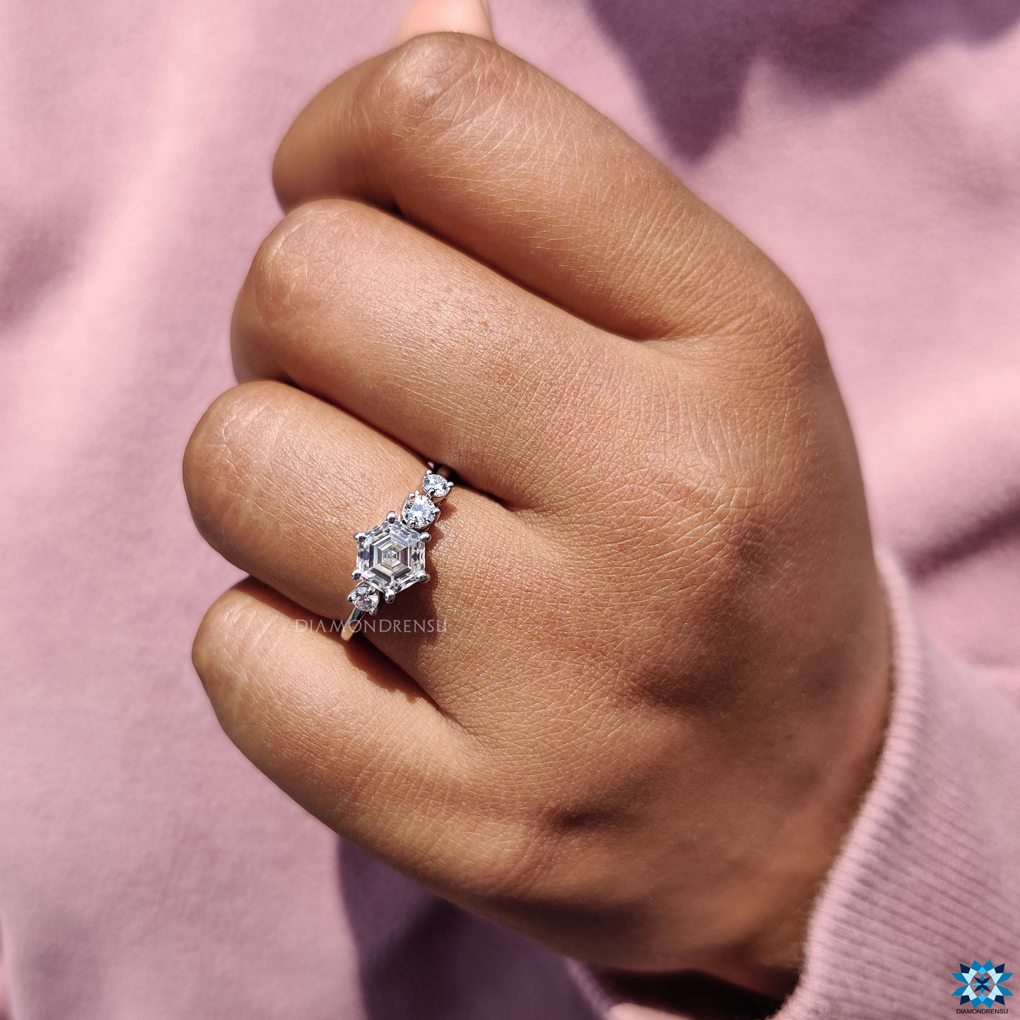 Three round cut moissanite stones in a handmade hexagon engagement ring.

