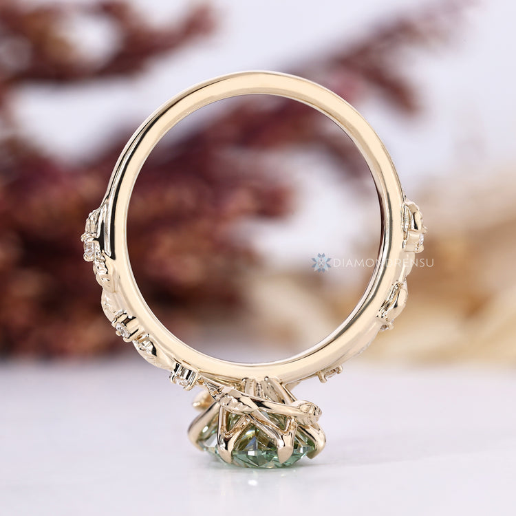 Handmade green diamond ring with round side stones.