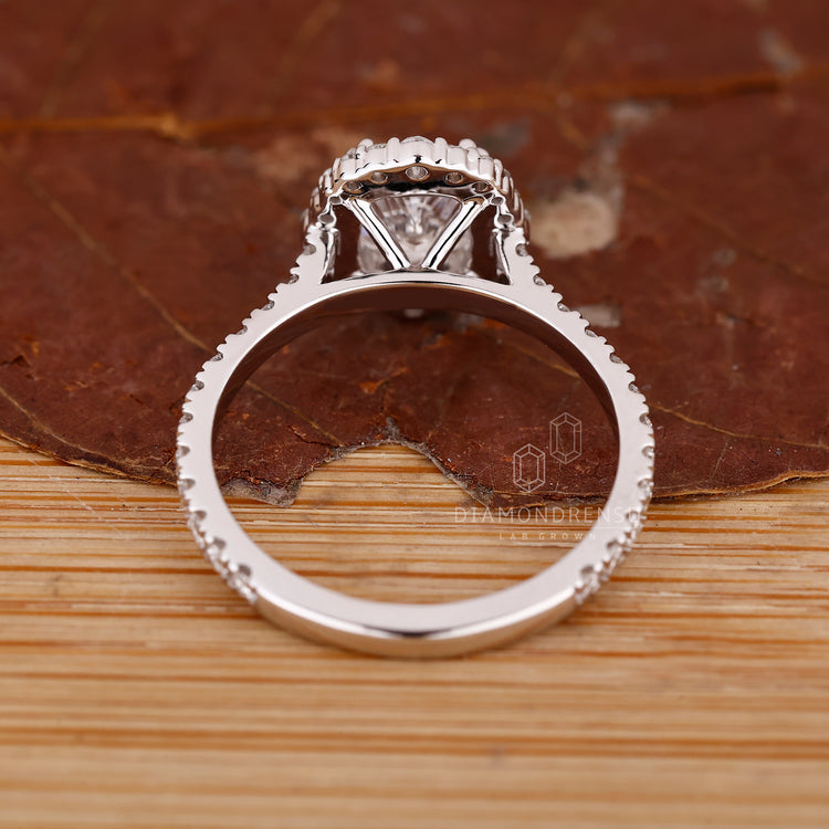 Cushion diamond ring with cathedral band and claw prongs.