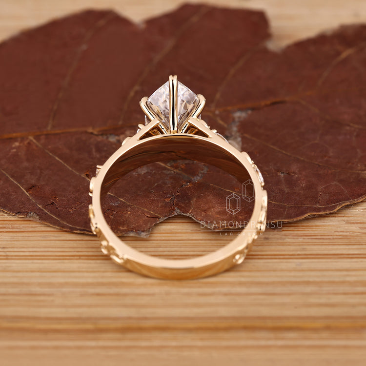 Marquise diamond ring with leaf style prongs and tapered band.